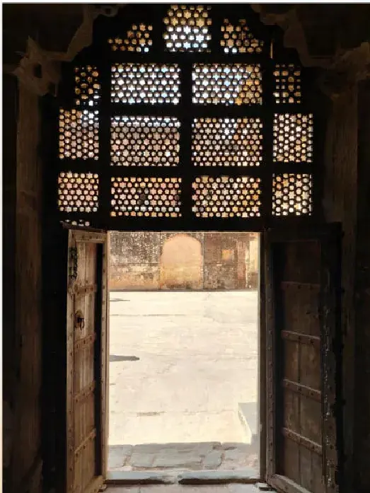 A jali screen and open door onto a courtyard