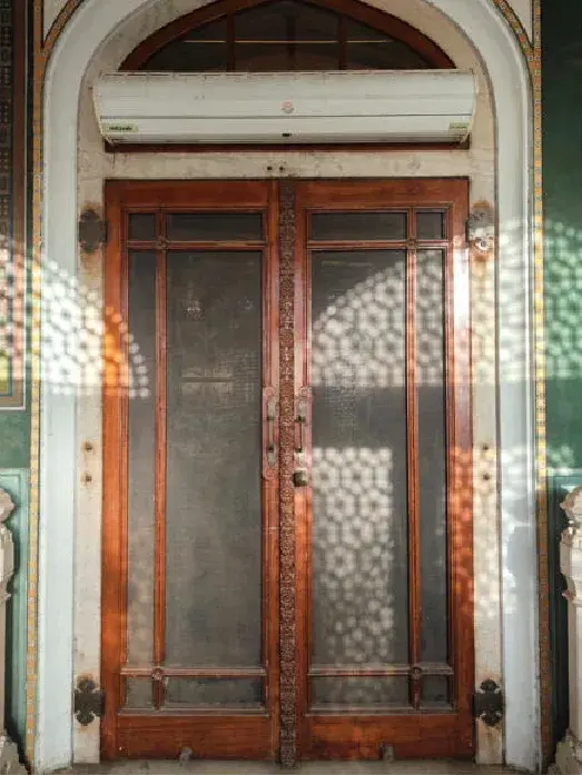A timber door with patterned light across it